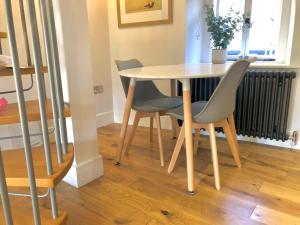 a table and chairs in a room with a staircase at 3 The Olde Barn Apartments in Stamford +1 photo
