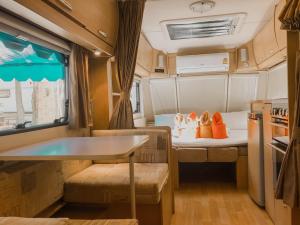 an rv with two beds and a table in it at Beach House Camp in Na Jomtien