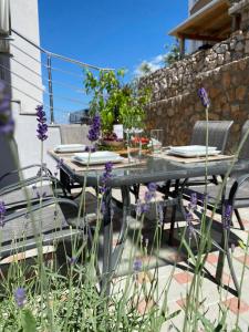 a table and chairs on a patio with purple flowers at Apartment Delic in Crikvenica +1 photo
