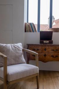 a room with a chair and a desk with a laptop at Domaine des Pousses, gîte au coeur d'un village de campagne in Droue-sur-Drouette +12 photos