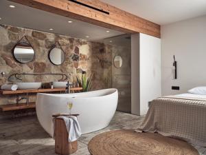 a bathroom with a large tub in a bedroom at Gloria Maris Hotel Suites and Villa in Laganas