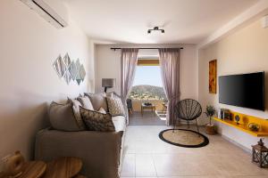 un soggiorno con divano e TV di Villa Mariva , south Crete , Triopetra a Triopetra