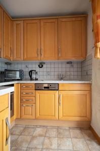 a kitchen with wooden cabinets and a stove at Ferienhaus Schaumbergblick in Britten