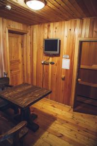 Habitación de madera con mesa y TV en la pared en Dmitrov Golf Resort быв Сорочаны, en Kurovo