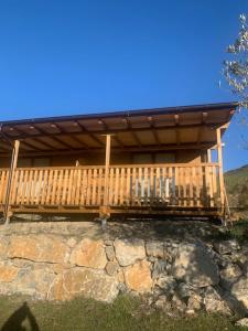 eine große Holzterrasse auf einer Steinmauer in der Unterkunft Camping Ezcaba in Maquirriain