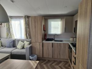 eine kleine Küche und ein Wohnzimmer in einem Wohnwagen in der Unterkunft Mawgan Pads Newquay Bay in Newquay Bay Resort