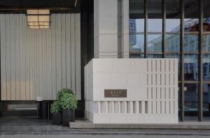 a building with a potted plant in front of it at Empark Prime Hotel Beijing in Beijing