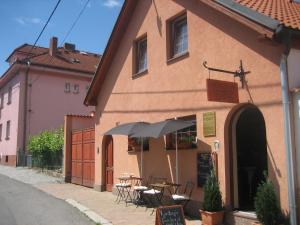 a building with tables and an umbrella on a street at Penzion Ryba in Rožmitál pod Třemšínem