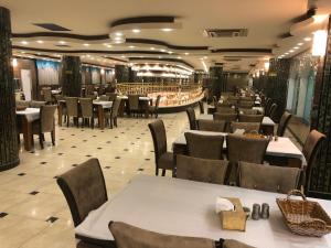une salle à manger avec des tables et des chaises dans un restaurant dans l'établissement Dur Kassir Alkadhimiya Hotel, à Karbala