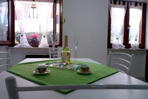 Appartamento La Rocca في تورتولي: طاولة مع زجاجة من النبيذ على منديل أخضر