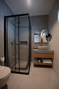 uma casa de banho com um chuveiro e um lavatório. em Regia Mare Beach Hotel Bodrum em Ortakent