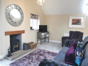 a living room with a couch and a fireplace at The Coach House Apartment at Cefn Tilla Court, Usk in Usk
