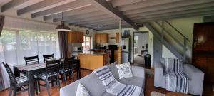 a living room and kitchen with a table and chairs at DullVino Cottage @ Critchley in Dullstroom