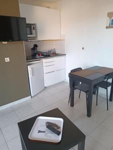 eine kleine Küche mit einem Tisch und einem Tisch sidx sidx sidx sidx in der Unterkunft 65 Rue Pierre Rameil Appartement in Cavalaire-sur-Mer