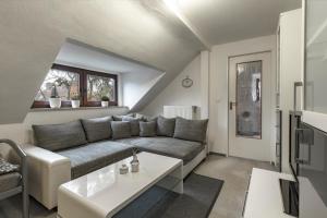 ein Wohnzimmer mit einem Sofa und einem Tisch in der Unterkunft Ferienwohnung-Fuhlsbüttel-Hamburg in Hamburg