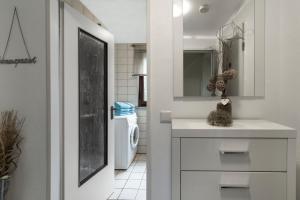 Baño blanco con lavabo y aseo en Ferienwohnung-Fuhlsbüttel-Hamburg, en Hamburgo