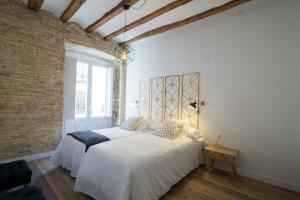 a bedroom with two beds and a brick wall at Apartamentos Almada in Zaragoza