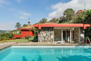 a villa with a swimming pool in front of a house at El Jardín de Santa Bígida in Santa Brígida