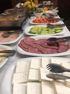 een tafel met borden met vlees en groenten bij Семеен хотел Анна-Кристина in Vidin
