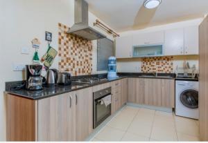 cocina con fregadero y fogones horno superior en Westpoint Suites by Senga en Nairobi