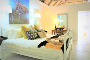 a bedroom with a white bed with pillows at Shikwari Nature Reserve in Hoedspruit