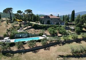 una finca con piscina frente a una casa en Relais Il Pozzeto, en Anghiari