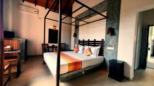Un dormitorio con una cama con dosel en una habitación en Anama by Queens Mount en Tangalle