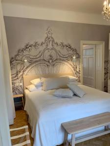 ein Schlafzimmer mit einem weißen Bett mit einem großen Kopfteil in der Unterkunft White Flat by GrazRentals with cool location & free parking in Graz