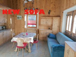ein Wohnzimmer mit einem Tisch und einem blauen Sofa in der Unterkunft Al Beltram in Livigno