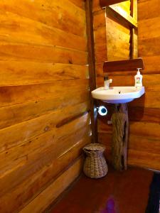 a bathroom with a sink in a wooden wall at Wilpattu Green Cabin in Achchamulai +230 photos