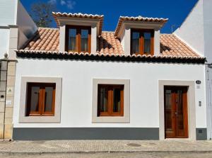 Casa do Marquês في فيلا ريال دي سانتو انطونيو: بيت ابيض بسقف احمر