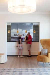 two people standing at a counter in a living room at Dorint Resort Baltic Hills Usedom in Korswandt