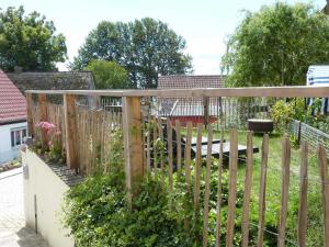 einen Holzzaun mit einer Bank im Garten in der Unterkunft Kamminke - Uns lütt Hus in Kamminke