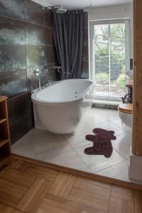 a bathroom with a bath tub on a tiled floor at Allika Holiday House in Pärnu +59 photos