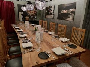 a long wooden table with wine glasses and napkins at Landhaus Hohenlohe in Rot am See