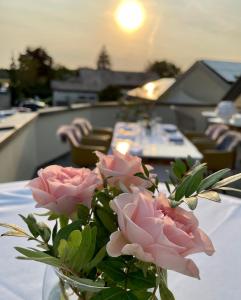 a vase filled with pink roses sitting on a table at Landhaus Hohenlohe in Rot am See