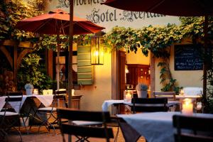 ein Restaurant mit Tischen, Stühlen und Sonnenschirmen in der Unterkunft Hotel & Restaurant Linde in Münstertal