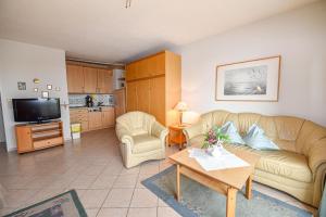 a living room with a couch and a table at "Appartementhaus Deichgraf" Appartement D341 in Döse +8 photos