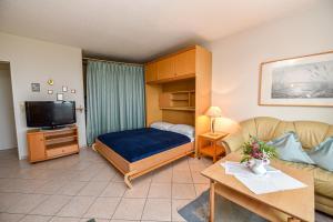 a living room with a bed and a couch at "Appartementhaus Deichgraf" Appartement D341 in Döse