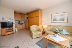 a living room with a couch and chairs and a tv at "Appartementhaus Deichgraf" Appartement D341 in Döse