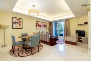 sala de estar con mesa y sofá en Royal Club By RVHR, Grandeur Residence Crescent Palm Jumeirah en Dubái