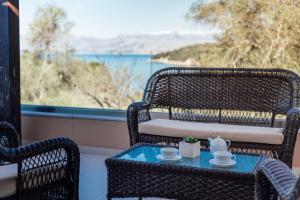 two wicker chairs and a table with two cups on it at Villa Breeze & Villa Coco by Konnect, Avlaki Beach in Kassiopi