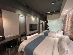 a hotel room with two beds and a television at Bentley Hotel in Zhongli