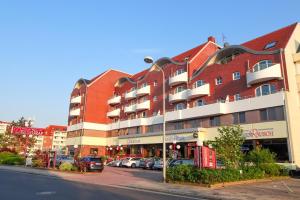 ein Gebäude auf einer Straße mit davor geparkt in der Unterkunft "Appartementhaus Deichgraf" Appartement D445 in Döse
