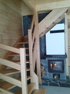 a staircase in a log cabin with a fireplace at DOMEK NA WIERCHU in Kluszkowce