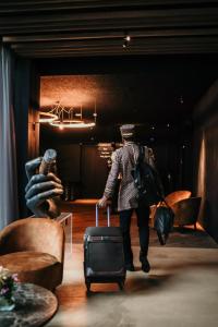 a man walking through a room with a suitcase at Hotel Sanglier in Durbuy