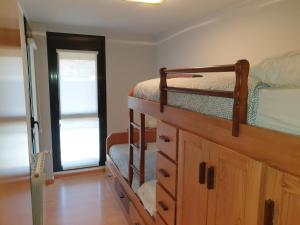 a bedroom with two bunk beds and a dresser at Apartamento Vive Jaca in Jaca