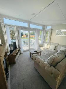 a living room with a couch and a tv at Brians Lodge with Hot Tub in Pocklington