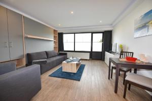 ein Wohnzimmer mit einer Couch und einem Tisch in der Unterkunft Haus "Jan am Strand" Appartement JAN002 in Döse