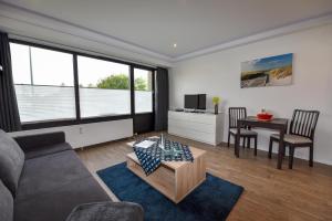 ein Wohnzimmer mit einer Couch und einem Tisch in der Unterkunft Haus "Jan am Strand" Appartement JAN002 in Döse